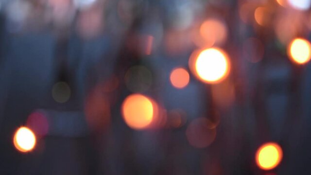 Multicolored bokeh lights twinkle on black background. New year's holiday backdrop. Abstract blurred Christmas festive video.
