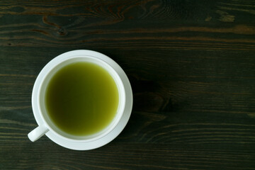 Top View of a Cup of Hot Matcha Green Tea Isolated on Block Wooden Table