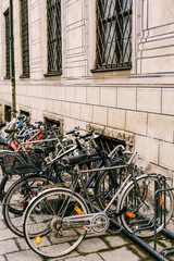 Fototapeta na wymiar Bicycle parking by a beige building with barred windows