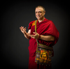 portrait of a Buddhist monk in a red kesa robe with ritual attributes