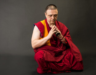 Tibetan Buddhist monk teacher in a burgundy yellow outfit suit © Serhii Prystupa