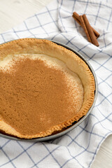 Homemade Sugar Cream Pie in a baking dish on a white wooden background, side view.