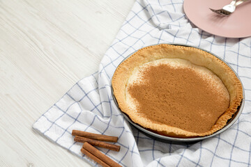 Homemade Sugar Cream Pie in a baking dish on a white wooden surface, side view. Copy space.