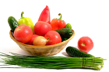 Fresh vegetables sweet bell peppers, cucumbers, tomatoes, onions in basket white background.