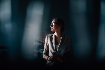 Portrait businesswoman with glasses in the office with a book in hand