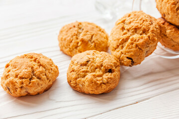 Homemade oatmeal cookies on white wooden table with milk on background