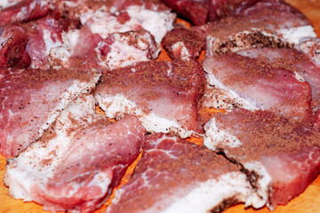 Fresh green pork chips with spices on a wooden board