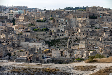 Obraz premium Panoramic view of Sassi di Matera a historic district in the city of Matera, well-known for their ancient cave dwellings from the Belvedere di Murgia Timone, Basilicata, Italy