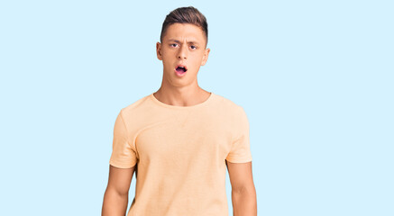 Fototapeta premium Young handsome man wearing casual clothes in shock face, looking skeptical and sarcastic, surprised with open mouth