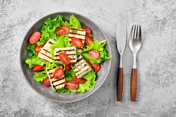 Top view of salad with grilled cheese, tomato and wine sauce
