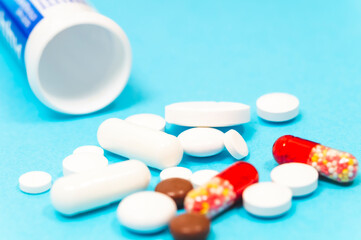 pills and thermometer on a blue background, the concept of a flu epidemic