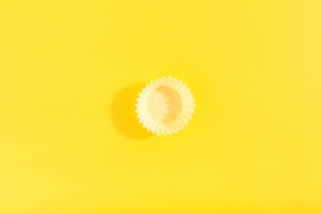 Trendy pattern made with yellow cap on bright yellow background. Minimal concept. Flat lay, copy space, top view.