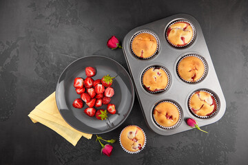Strawberry muffins with fresh berries, flat lay on black concrete background