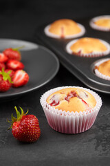 Strawberry muffin dessert with fresh strawberry on dark background - summer pasrty