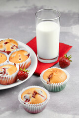 Strawberry muffins with fresh milk glass on grey concrete background