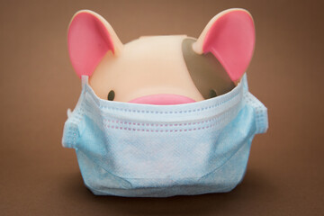 Piggy Bank Wearing Face Mask on Brown Background