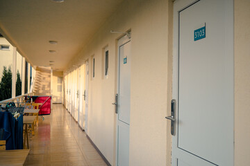 Row of doors to motel rooms in sunny weather. White doors to motel rooms.
