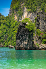 Fototapeta na wymiar Eroded overgrown limestone rocks in Phang Nga Bay, Ao Phang Nga Marine National Park, Thailand,
