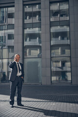 Handsome businessman talking on mobile phone outdoors