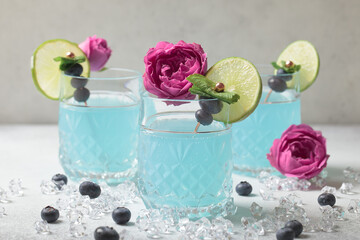 Obraz na płótnie Canvas Blue soda. Ice blue cocktail glass. Синий гавайский коктейль на белом фоне с лаймом. Blue curacao cocktail. Blue drink with fruit garnish