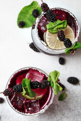 Bramble cocktail with blackberries and crashed ice
