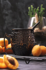 Apricot juice and fresh fruits. Apricots lie on dark background. Low Key shot
