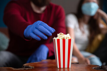 Couple wearing protection gloves and mask for Covid-19, coronavirus concept, date night in...