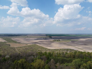 Beautiful blue sky over woodland, aerial view. Agricultural land.
