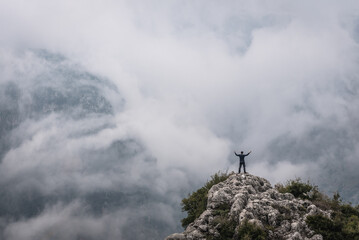 Man on a rock above Kadisha Valley also spelled as Qadisha, view from BLouza village in Lebanon