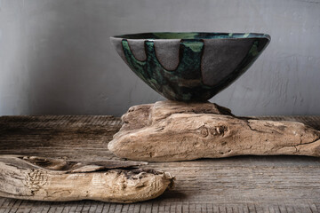 Handmade ceramics in the style of wabi sabi. Grey clay bowl with an abstract green pattern.