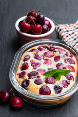 Clafouti cherry pie on black stone background