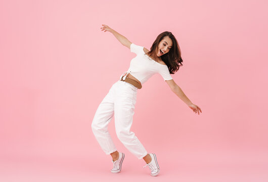 Image of delighted brunette woman dancing and laughing