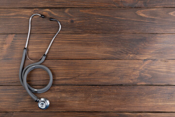 Workplace of a doctor. Stethoscope on wooden desk background - Healthcare concept