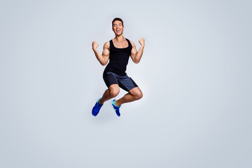 Fototapeta na wymiar Full length body size view of his he nice attractive sportive muscular cheerful glad guy jumping celebrating great accomplishment rejoicing isolated over light gray pastel color background