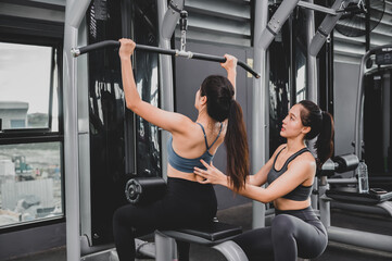 Fototapeta na wymiar Asian woman exercise and lifestyle at fitness gym. Sporty woman workout with trainer. Wellness and healthy for bodybuilding.