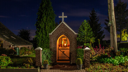 Little chapel  with Antonius of Padua with burning candles during a starry sky