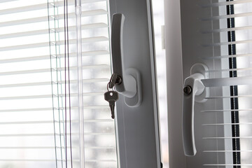 White plastic window with shutters. Open to ventilate. Keys in the window, child protection.