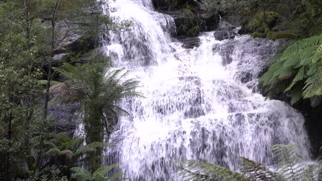 Large waterfall flowing over rocky mountain cliff