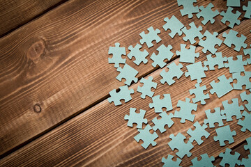 Puzzle. Many puzzle pieces on a wooden table. The concept of collective thinking.