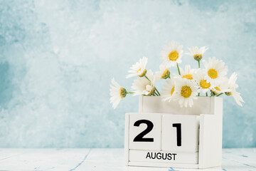 White cube calendar for august decorated with daisy flowers
