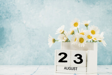 White cube calendar for august decorated with daisy flowers