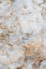 Light rough surface of marble with red stains. Closeup of raw uneven stone, natural material, beautiful rock texture. Vertically background.