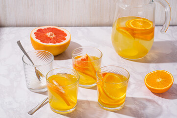 lemonade in glass and jug. Summer refreshing drink. Cold detox water with lemon.