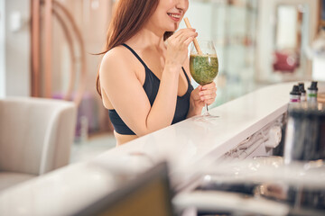 Woman in a sporty top enjoying her drink