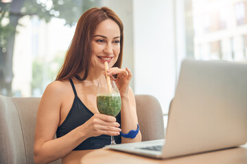 Smiling woman gazing at the laptop screen