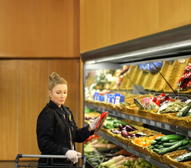 Supermarket shopping,  gloves,woman buying vegetables at the market	