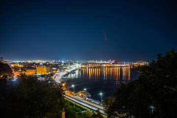 Comet C/2020 F3 (NEOWISE) at night over the city. Kyiv. Dnieper River. Ukraine.