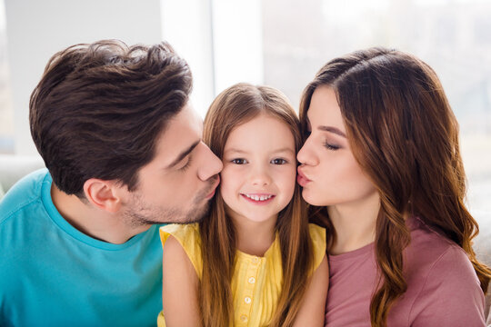 Close up photo of idyllic family portrait loving mother father kiss little kid girl in house indoors