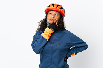 Teenager cyclist woman isolated on white background having doubts