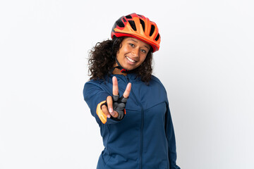 Teenager cyclist woman isolated on white background smiling and showing victory sign